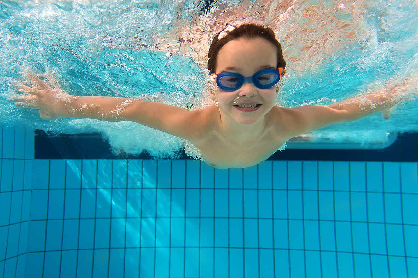 Ein Kind taucht im Schwimmerbecken als Symbol für den Anfängerschwimmunterricht  